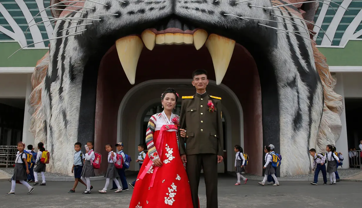 Pengantin berpose di Kebun Binatang di Pyongyang, Korea Utara (15/9). Kebun binatang ini memiliki lebih dari 5.000 hewan liar, terdiri dari total 650 spesies, dan mencakup area seluas sekitar satu kilometer persegi. (AP Photo/Kin Cheung)