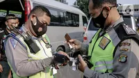 Polisi mengumpulkan kunci kendaraan travel gelap yang disita jajaran Direktorat Lalu Lintas Polda Metro Jaya, Jakarta, Kamis (29/4/2021). Sebanyak 115 kendaraan travel gelap diamankan karena diduga kuat mengangkut pemudik di tengah masa pengetatan larangan mudik 2021. (Liputan6.com/Faizal Fanani)