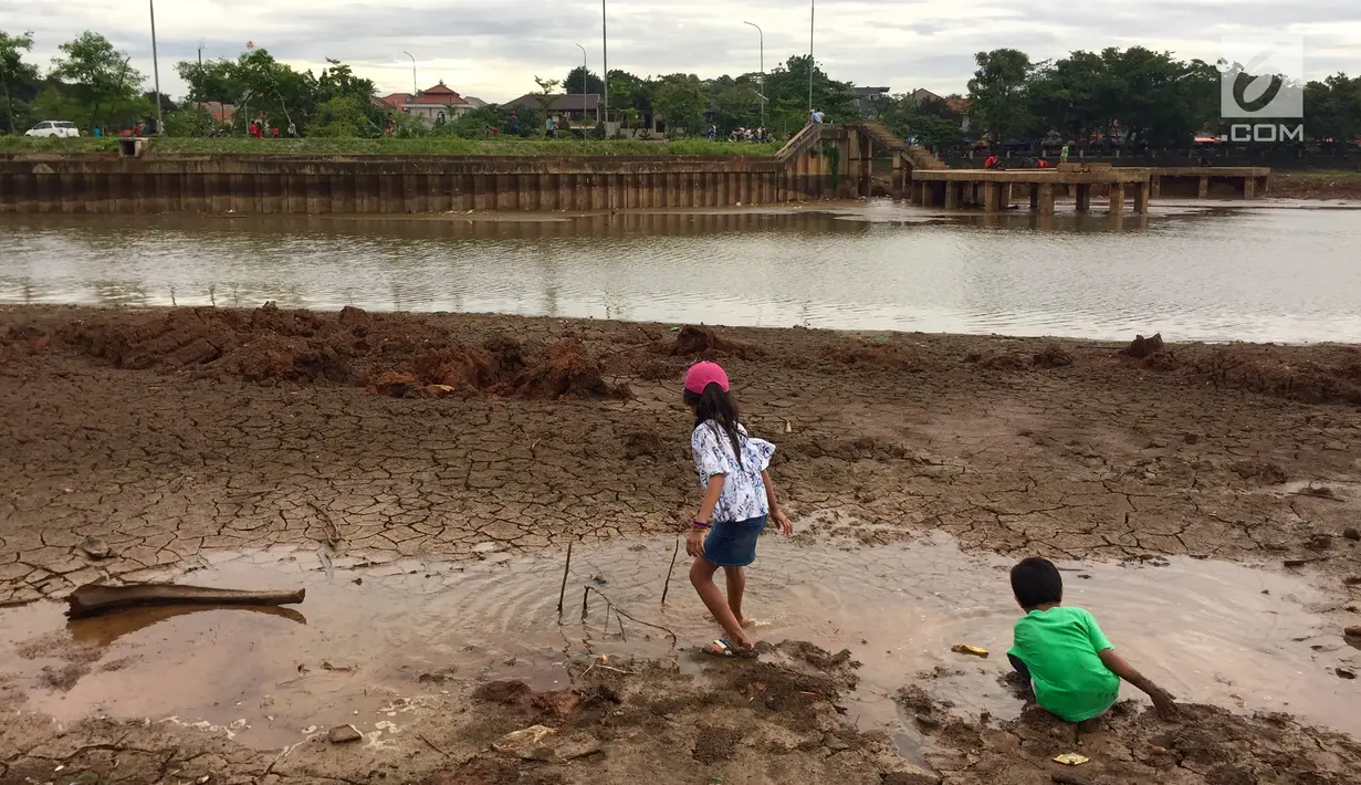 Anak-anak bermain di sekitar kawasan Danau Setu Babakan yang mengering di Jakarta, Jumat (5/1). Mereka bermain sambil mengisi waktu libur sekolah. (Liputan6.com/Immnanuel Antonius)