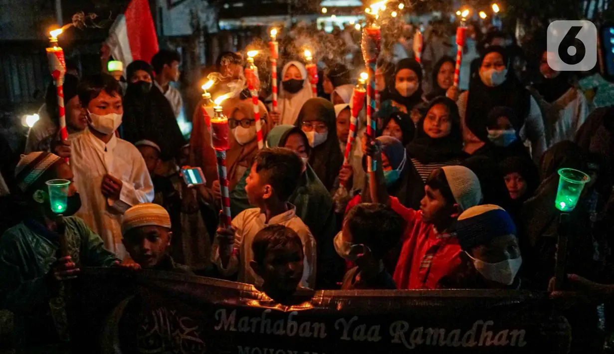 Warga mengikuti pawai obor menyambut Ramadan di kawasan Matraman Dalam, Jakarta, Minggu (27/3/2022). Pawai obor tersebut juga digelar untuk meningkatkan silaturahmi dan ukhuwah sesama umat Muslim serta menyemarakkan syiar Islam di Ibu Kota. (Liputan6.com/Faizal Fanani)