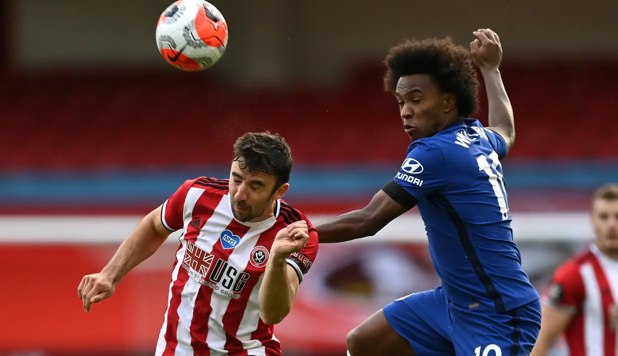 Penyerang Chelsea, Willian melompat saat berebut bola dnegan pemain Sheffield United, Enda Stevens pada pekan ke-35 Liga Inggris di Bramall Lane, Minggu (12/7/2020) dini hari WIB. Chelsea dihajar 0-3 oleh Sheffield United. (Shaun Botterill/Pool via AP)