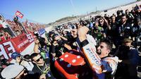 Marc Marquez (kanan) merayakan keberhasilan meraih gelar juara dunia MotoGP 2017 bersama fans pada balapan MotoGP Valencia di Ricardo Tormo Circuit, Cheste, (12/11/2017). Gelar tersebut merupakan yang keempat buat Marquez.  (AFP/Jose Jordan)