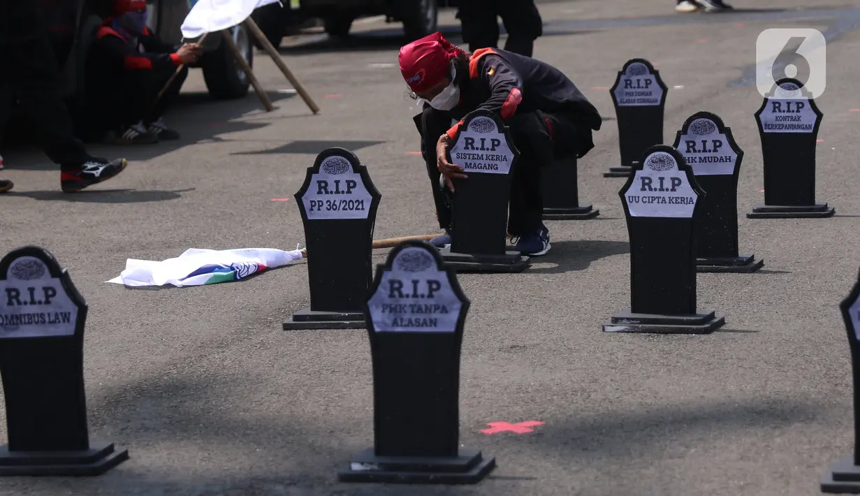 Buruh meletakkan puluhan nisan di sekitar area Monas, Jakarta, pada Hari Buruh Internasional, Sabtu (1/5/2021). Nisan hitam itu dihiasi tulisan yang mewakili perasaan para buruh, Antara lain RIP PHK Murah, Bebasnya Outsourcing, RIP Cuti Hamil, RIP Satuan Upah-Perjam. (Liputan6.com/Angga Yuniar)