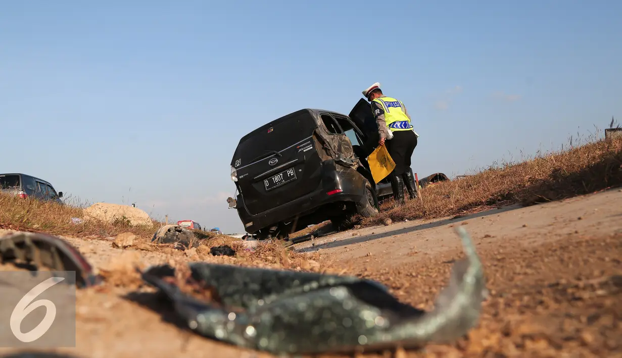 Petugas kepolisian memeriksa kendaraan yang mengalami kecelakaan di Tol Cipali, Jawa Barat, Senin (13/7/2015). Mobil bernomor polisi D 1807 PB tersebut menabrak penanda jalan di Km 149+800. (Liputan6.com/Herman Zakharia)