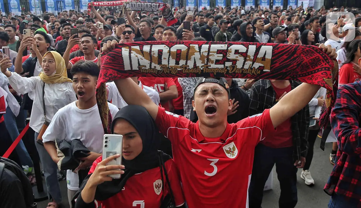 Pendukung Skuad Garuda membentangkan syal jelang nonton bareng pertandingan putaran ketiga Kualifikasi Piala Dunia 2026 zona Asia antara Timnas Indonesia melawan Australia melalui layar videotron di area lingkar luar Stadion Utama Gelora Bung Karno, Jakarta, Kamis (20/3/2025). (Liputan6.com/Angga Yuniar)