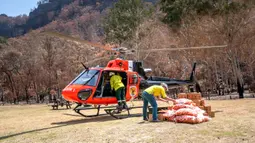 Petugas memuat wortel dan ubi jalar untuk walabi korban kebakaran hutan di sepanjang Pantai Selatan New South Wales pada 10 Januari 2020. Sekitar 1.000 kg ubi dan wortel ditumpahkan dari helikopter di berbagai wilayah dalam sepekan terakhir. (STR/NSW NATIONAL PARKS AND WILDLIFE SERVICES/AFP)