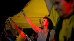 Sejumlah demonstran memegang spanduk dalam warna bendera Brasil untuk dibentangkan saat menggelar aksi protes di Rio de Janeiro, Brasil (3/4). Mereka menggelar aksi protes terkait mantan Presiden Brasil Luiz Inacio Lula da Silva. (AP / Silvia Izquierdo)