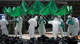 Sejumlah petugas menyiapkan tenda untuk memisahkan unggas di sebuah pasar di Hong Kong, (7/6).  Pihak berwenang memutuskan untuk menangguhkan perdagangan unggas hidup setelah pemeriksaan menunjukkan adanya virus flu burung H7N9. (REUTERS/Bobby Yip)