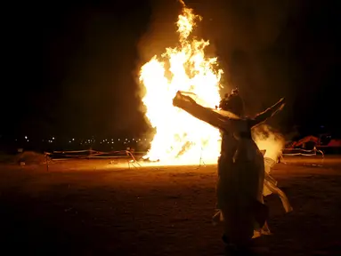 Penari beratraksi di depan bakaran api saat jelang perayaan "Jeongwol Daeboreum" di Seoul, Korea Selatan, Minggu (21/2). Tradisi perayaan "Jeongwol Daeboreum" ini merupakan bagian dari peringatan hari besar dalam penanggalan Imlek. (REUTERS/Kim Hong-Ji)