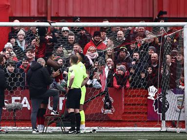 Pemain Tamworth, Beck-Ray Enoru memperbaiki masalah pada jala gawang sebelum kick-off Piala FA 2024/2025 melawan Tottenham Hotspur di The Lamb Ground, Tamworth, Inggris, Minggu (12/01/2025) waktu setempat. (AFP/Henry Nicholls)
