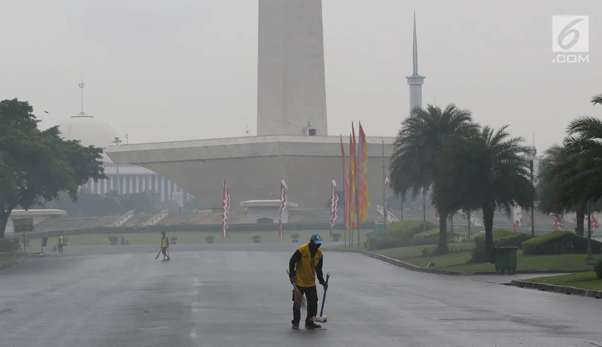 Petugas menyapu sampah yang tercecer di kawasan Monas, Jakarta, Senin (3/11). Kesigapan petugas kebersihan pasca reuni 212 membuat kawasan tersebut kembali bersih meskipun sehari sebelumnya dipenuhi ratusan ribu orang. (Liputan6.com/Immanuel Antonius)