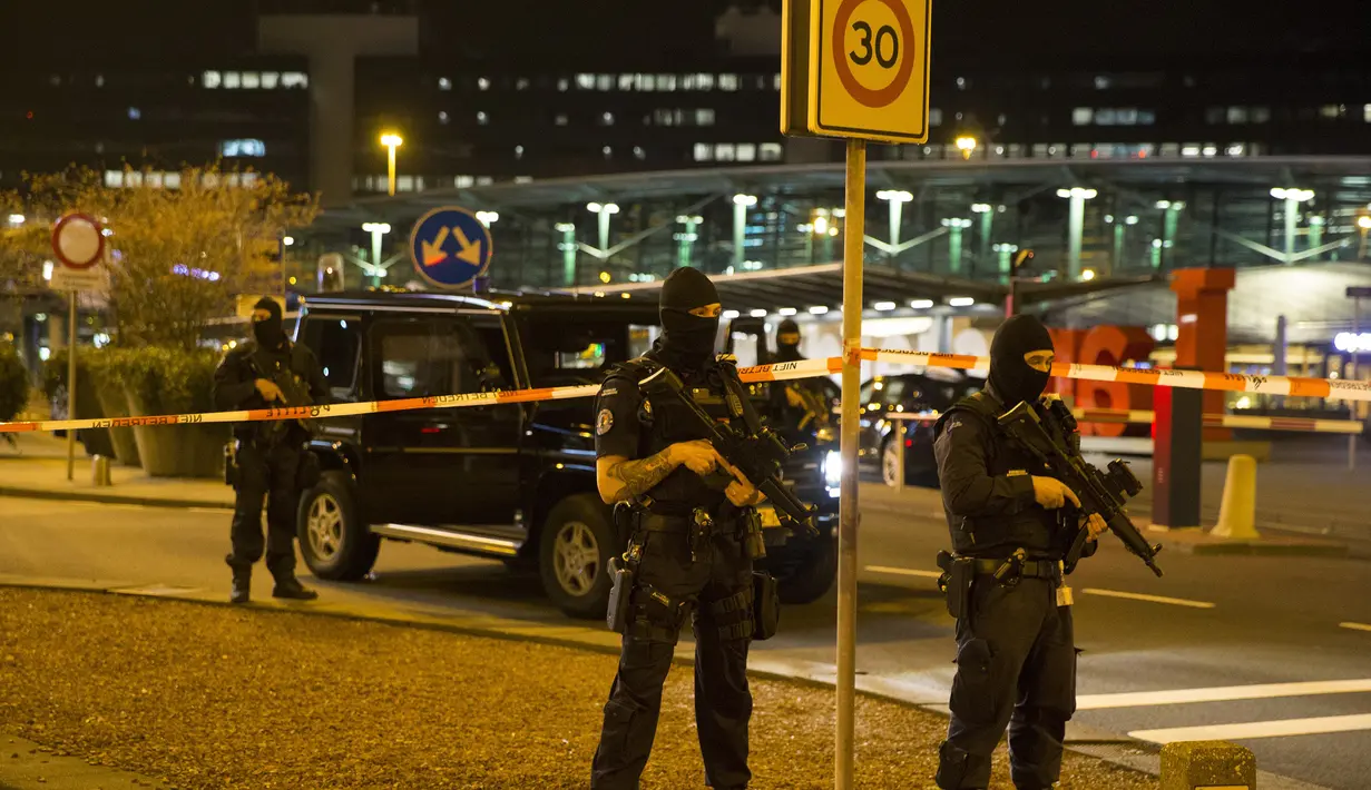Pasukan bersenjata berjaga di area Bandara Internasional Schiphol, Amsterdam, Belanda, yang ditutup menyusul ancaman bom, Selasa (12/4).  Pihak kepolisian menangkap seorang pria dengan perilaku mencurigakan terkait ancaman bom. (Michel van Bergen/ANP/AFP)