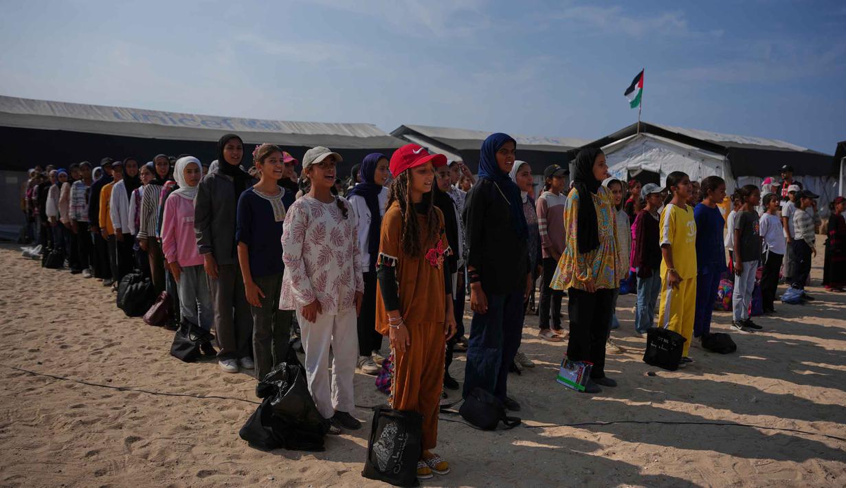 Pembelajaran kembali berlangsung meski dalam kondisi yang sangat menantang di tengah reruntuhan dan keterbatasan fasilitas. Tampak dalam foto, para siswa menghadiri upacara pagi di sebuah sekolah yang didirikan di pantai di Khan Younis, bagian selatan Jalur Gaza, pada Rabu, 12 November 2025. (AP Photo/Abdel Kareem Hana)