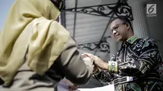 Gubernur DKI Jakarta Anies Baswedan bersalaman dengan personel Satpol PP saat pelapasan di halaman Pendopo Balai Kota, Jakarta, Kamis (29/3). (Liputan6.com/Faizal Fanani)