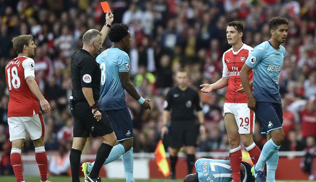 Wasit memberikan gelandang Arsenal, Granit Xhaka, kartu merah saat melawan Swansea pada laga Premier League di Stadion Emirates, London, Sabtu (15/10/2016). Arsenal menang 3-2 atas Swansea. (Reuters/Hannah McKay)