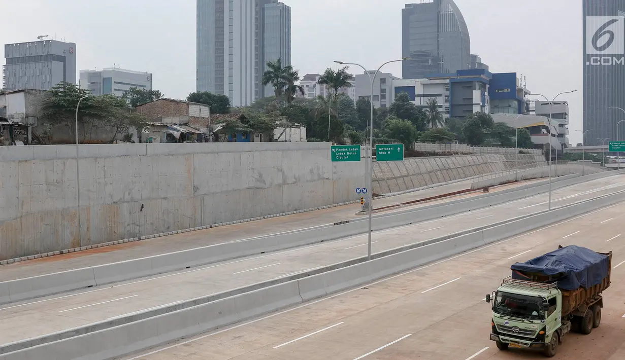 Truk melintas di dekat proyek Tol Depok-Antasari (Desari) seksi 1 di Jakarta Selatan, Selasa (17/7). BPJT Kementerian PUPR menyatakan tol seksi 1 yang menghubungkan Antasari-Brigif sepanjang 5,80 km bakal segera selesai. (Liputan6.com/Immanuel Antonius)