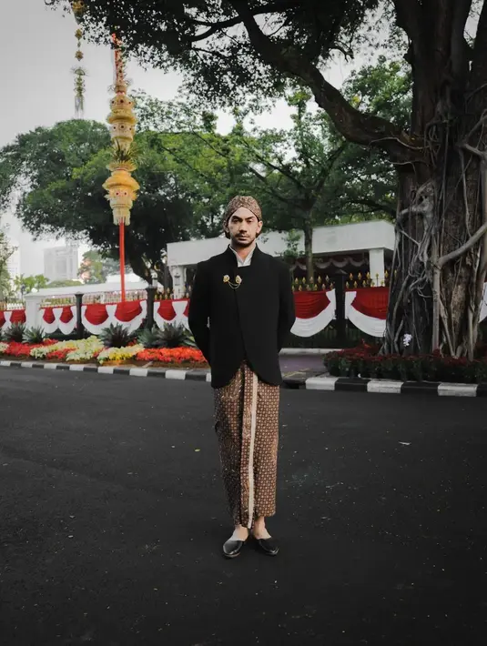 <p>Kemudian ada Reza Rahadian, salah satu selebritas tanah air yang turut hadir di Istana Negara saat Upacara HUT ke-77 RI. Reza Rahadian mengenakan busana adat Jawa dengan beskap modern berwarna hitam dari Kraton World rancangan Auguste Soesastro, dipadu dengan kain batik sebagai bawahan, dan sentuhan bros dari Tulola, serta blangkon khas Solo.</p>
