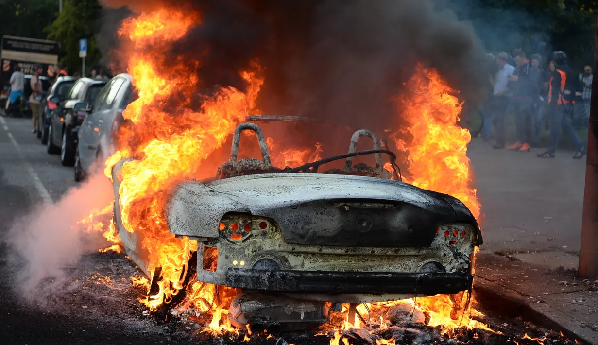 Sebuah mobil terbakar dalam unjuk rasa menentang penyelenggaraan Konferensi Tingkat Tinggi (KTT) G20 di Hamburg, Jerman, Kamis (6/7). Sejumlah pemimpin dunia berkumpul dalam KTT G20 di Hamburg pada 7-8 Juli 2017. (Christophe Gateau/dpa via AP)