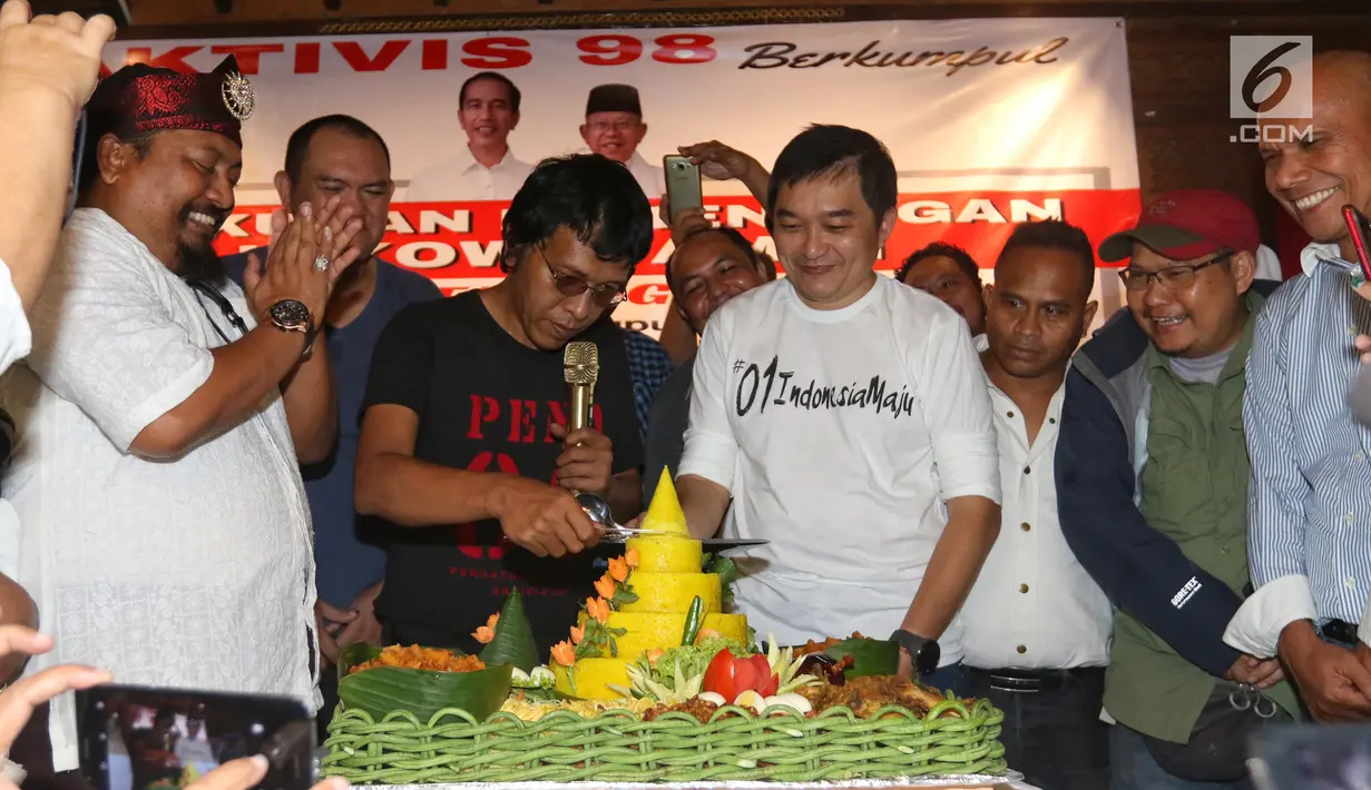 Aktivis 98 Adian Napitupulu memotong tumpeng saat menggelar diskusi sekaligus syukuran kemenangan capres-cawapres nomor urut 01 Joko Widodo atau Jokowi dan Ma'ruf Amin versi quick count di Jakarta, Minggu (21/4). Diskusi bertajuk 'Setelah Menang Mau Apa?'. (Liputan6.com/JohanTallo)