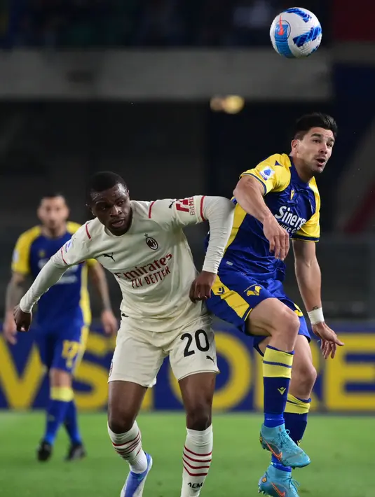 <p>Bek AC Milan Pierre Kalulu (kiri) berebut bola dengan penyerang Hellas Verona Giovanni Simeone pada laga pekan ke-36 Liga Italia musim 2021-22 di Stadion Marcantonio Bentegodi, Senin (9/5/2022) dini hari WIB. AC Milan kembali merebut puncak klasemen Liga Italia dari tangan Inter Milan usai menaklukkan Hellas Verona 3-1. (MIGUEL MEDINA / AFP)</p>