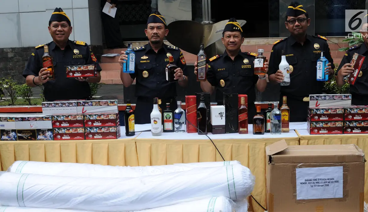 Petugas Bea Cukai menunjukkan rokok dan minuman beralkohol ilegal saat rilis di Banten, Banten (6/3). Barang bukti yang berhasil diamankan 7.743 tekstil barang impor, 14.940  minuman beralkohol illegal, dan 2.903.960 tembakau. (Merdeka.com/Arie Basuki)