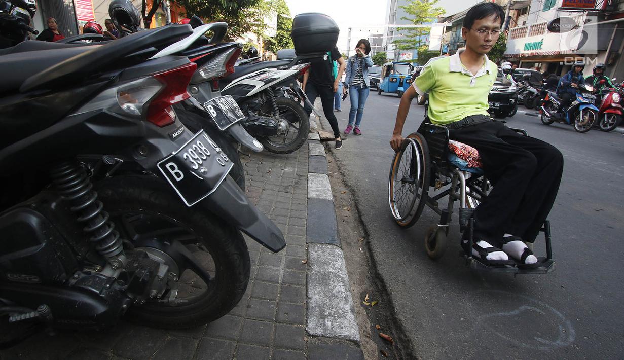 Penyandang disabilitas melintas di samping trotoar saat kampanye Bulan Patuh Pedestrian di Jalan Sabang, Jakarta, Rabu (30/8). Kampanye dilakukan untuk memantau fasilitas akses pejalan kaki untuk disabilitas. (Liputan6.com/Immanuel Antonius)