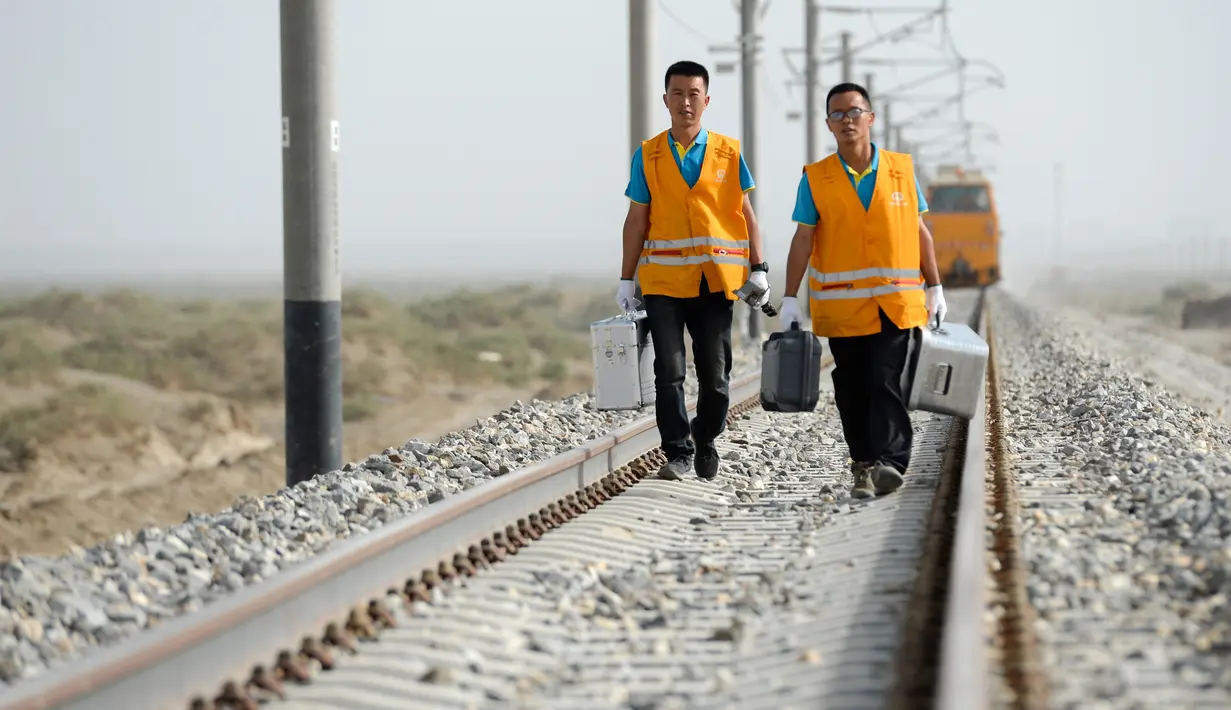 Para petugas pemeliharaan rel kereta api berjalan menuju lokasi tugas mereka di jalur kereta api Golmud-Korla di Daerah Otonom Uighur Xinjiang, China, pada 14 Juli 2020. Jalur kereta ini menurut jadwal pengoperasiannya akan dimulai pada 30 Oktober 2020. (Xinhua/Ding Lei)