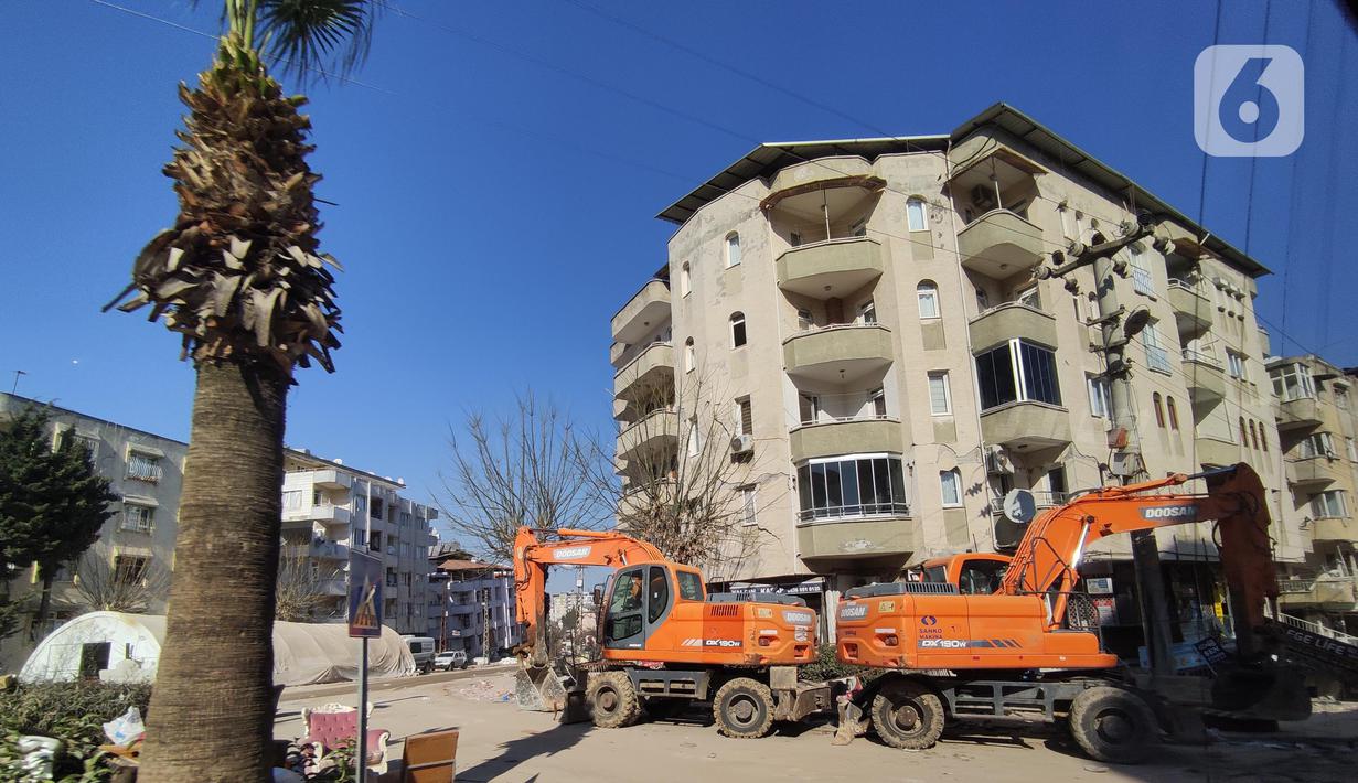 Sejumlah alat berat membongkar bangunan yang rusak di kawasan kota Antakya, Provinsi Hatay, Turki, Sabtu (18/2/2023). Pantauan tim Liputan6com di lokasi gempa, bangunan yang rubuh mayoritas adalah gedung apartemen. Saat ini akses menuju lokasi reruntuhan dibatasi oleh pihak berwenang setempat, hanya unsur terkait yang bisa masuk ke lokasi tersebut. (Liputan6.com/Andry Haryanto)