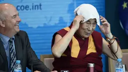 Dalai Lama meletakkan sapu tangan di kepalanya saat ia pidato di Dewan Eropa di Strasbourg, Perancis, Kamis (15/9). Ini adalah kunjungan Eropa pertama Dalai Lama setelah lima tahun. (AFP PHOTO/Frederick Florin)