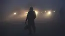 Kendaraan melaju dengan menyalakan lampu depan saat kabut tebal menyelimuti Lahore, Pakistan, 15 Desember 2021. Kabut tebal membuat kendaraan harus melaju lambat karena jarak pandang berkurang. (AP Photo/K.M. Chaudary)