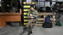 Seorang prajurit wanita Pasukan Pertahanan Teritorial Ukraina, cadangan militer Angkatan Bersenjata Ukraina, minum teh di garasi bawah tanah yang telah diubah menjadi pangkalan pelatihan dan logistik di Kiev, pada Jumat (11/3/2022). (Sergei SUPINSKY / AFP)