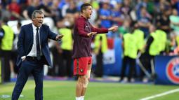 Cristiano Ronaldo bersama pelatih Portugal, Fernando Santos, memberikan instruksi kepada pemain Portugal saat melawan Prancis di laga Final Euro 2016 di Stade de France pada 10 Juli 2016. Portugal menang 1-0 atas Prancis. (AFP/Franck Fife)