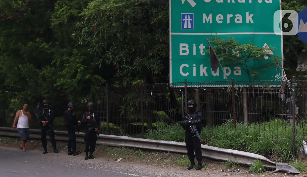 Personel Brimob bersenjata melakukan penjagaan ketat di depan pintu masuk Tol Bitung, Tangerang, Baten, Selasa (6/10/2020). Penjagan ketat dilakukan untuk mengamankan dan mencegah aksi buruh yang akan menggelar aksi menolak UU Cipta Kerja. (Liputan6.com/Angga Yuniar)