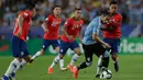 Bek timnas Uruguay, Martin Caceres menggiring bola dibayangi pemain Chile,  Erick Pulgar pada laga terakhir grup C Copa America 2019 di stadion Maracana, Senin (24/6/2019). Uruguay berhasil melaju ke perempatfinal dengan status juara Grup C usai mengalahkan Chile 1-0. (AP/Silvia Izquierdo)