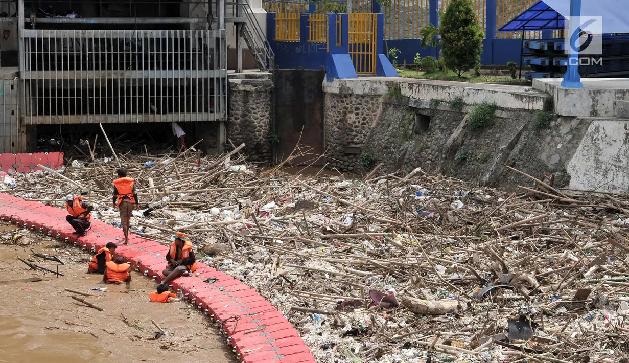 Petugas Dinas Lingkungan Hidup Pemprov DKI saat membersihkan sampah yang memenuhi sekitar Pintu Air Manggarai, Jakarta, Minggu (8/4). Menurut petugas, sebanyak 312 meter kubik sampah memenuhi pintu air. (Merdeka.com/Iqbal Nugroho)
