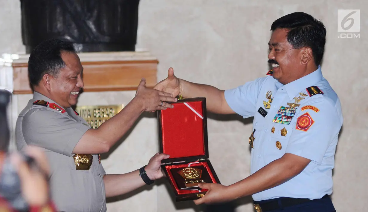 Panglima TNI, Hadi Tjahjanto (kanan) menyerahkan cenderamata kepada Kapolri Tito Karnavian saat pertemuan di Mabes TNI, Jakarta, Senin (11/12). Pertemuan bertujuan meningkatkan soliditas TNI-Polri dalam menjaga keamanan. (Liputan6.com/Helmi Fithriansyah)