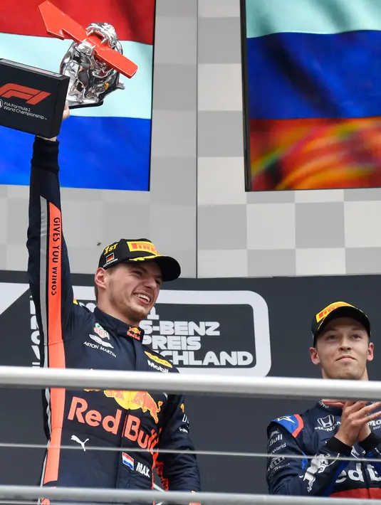 Pebalap Red Bull Max Verstappen (Kiri) mengangkat piala usai memenangkan F1 GP Jerman di Hockenheimring, Hockenheim, Minggu (28/7/2019). Ini adalah kemenangan kedua Verstappen pada persaingan F1 GP 2019. (AP Photo/Jens Meyer)