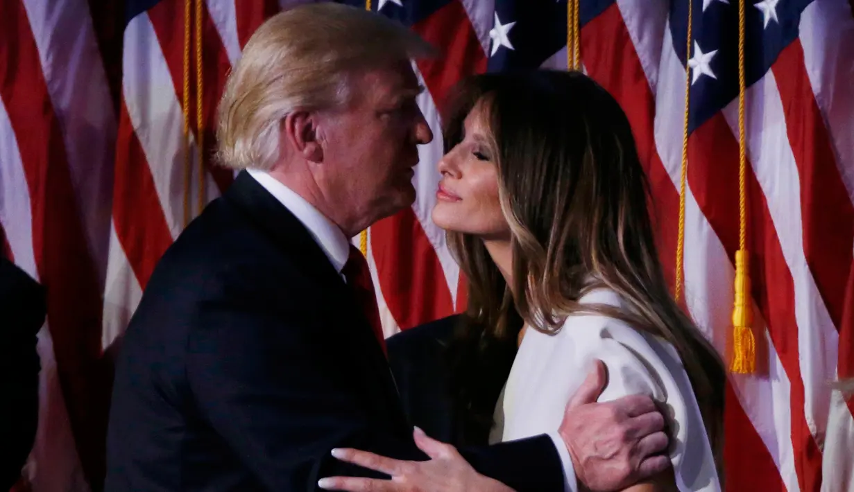 Presiden ke-45 AS, Donald Trump mencium istrinya, Melania usai menyampaikan pidato kemenangan di Manhattan, New York Rabu (9/11). Trump berhasil mendapat suara electoral votest lebih dari 270, sebagai syarat kemenangan Pilpres AS. (REUTERS/Jonathan Ernst)