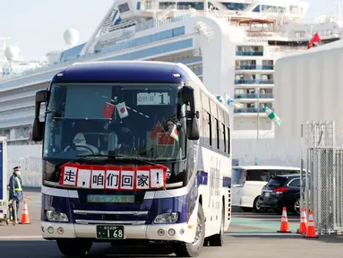 Bus dengan spanduk China bertuliskan 'Pergi, Kita Pulang!' membawa penumpang Hong Kong dari kapal pesiar Diamond Princess yang dikarantina di Yokohama, Jepang, Jumat (21/2/2020). Ratusan orang yang dinyatakan negatif virus corona (COVID-19) berangsur meninggalkan kapal. (AP Photo/Eugene Hoshiko)