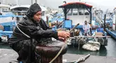 Seorang nelayan mengamankan perahunya saat Topan Kong-rey mendekati Taiwan, di wilayah Yilan pada 30 Oktober 2024. (I-Hwa CHENG/AFP)