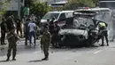 Petugas pertolongan pertama bekerja di sekitar kendaraan yang menjadi sasaran serangan pesawat tak berawak Israel di jalan raya dekat kota Jiyeh, Selatan Beirut, pada Rabu 13 Mei 2026. (MAHMOUD ZAYYAT/AFP)