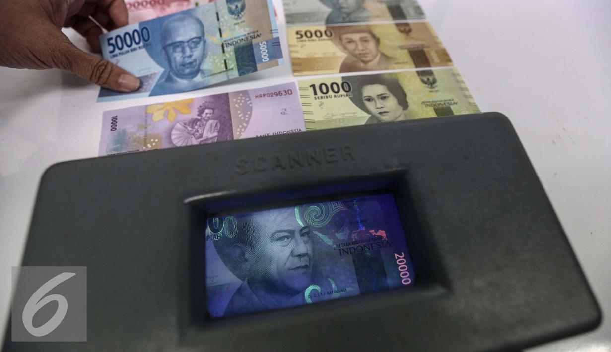 Petugas menunjukan pengaman uang saat peruri media visit di kantor Peruri, Karawang, Jawa Barat, Rabu (18/1). Ada unsur pengaman yang mudah dapat diketahui masyarakat dan ada yang hanya bisa diketahui spesialis. (Liputan6.com/Faizal Fanani)
