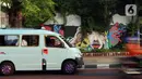 Angkutan umum melewati lukisan mural dari tangan PPSU yang memanfaatkan tanaman merambat hijau. (Liputan6.com/Johan Tallo)
