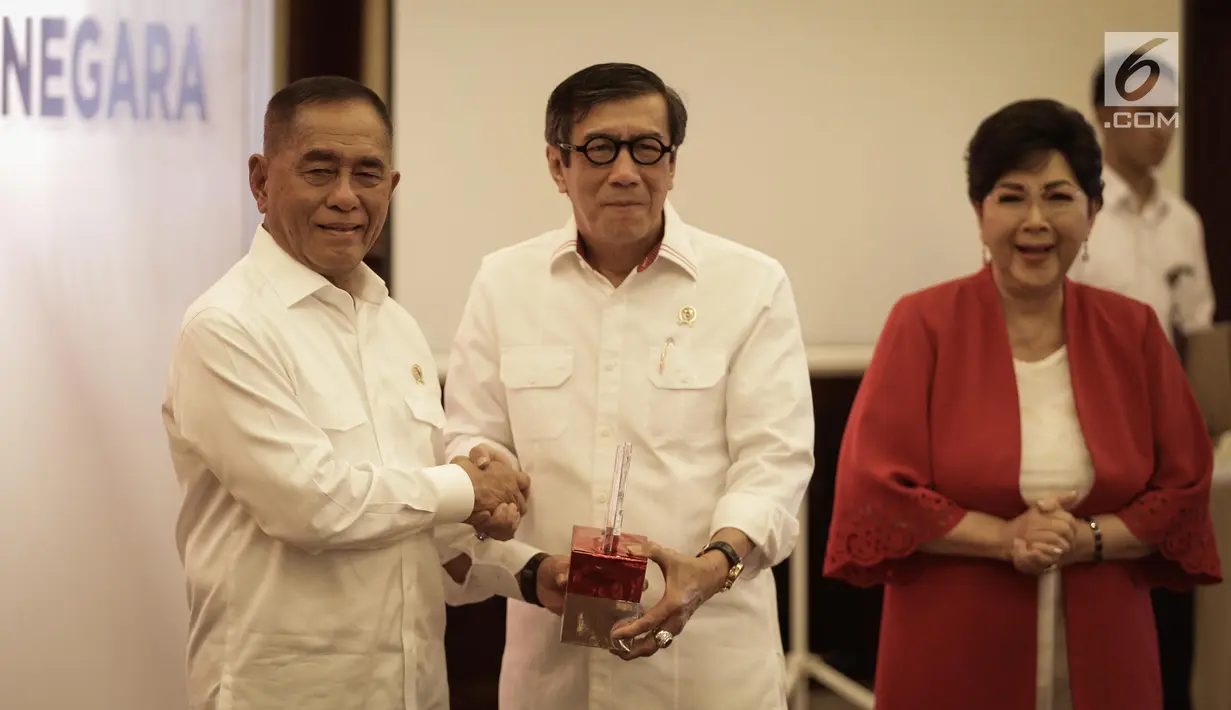 Menteri Pertahanan Ryamizard Ryacudu (kiri) memberikan dvd bela negara kepada Menkumham Yasonna Laoly (tengah) usai MoU pelaksanaan program bela negara dengan Menkumham di Kementerian Pertahanan, Jakarta, Rabu (21/6). (Liputan6.com/Faizal Fanani)
