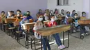 Para siswa mengikuti pelajaran pada hari pertama mereka kembali ke sekolah di Provinsi Hama, Suriah, Minggu (13/9/2020). Lebih dari tiga juta siswa bersekolah di daerah yang dikuasai pemerintah, menandai hari sekolah pertama di tengah langkah ketat untuk mencegah penyebaran COVID-19. (SANA via AP)