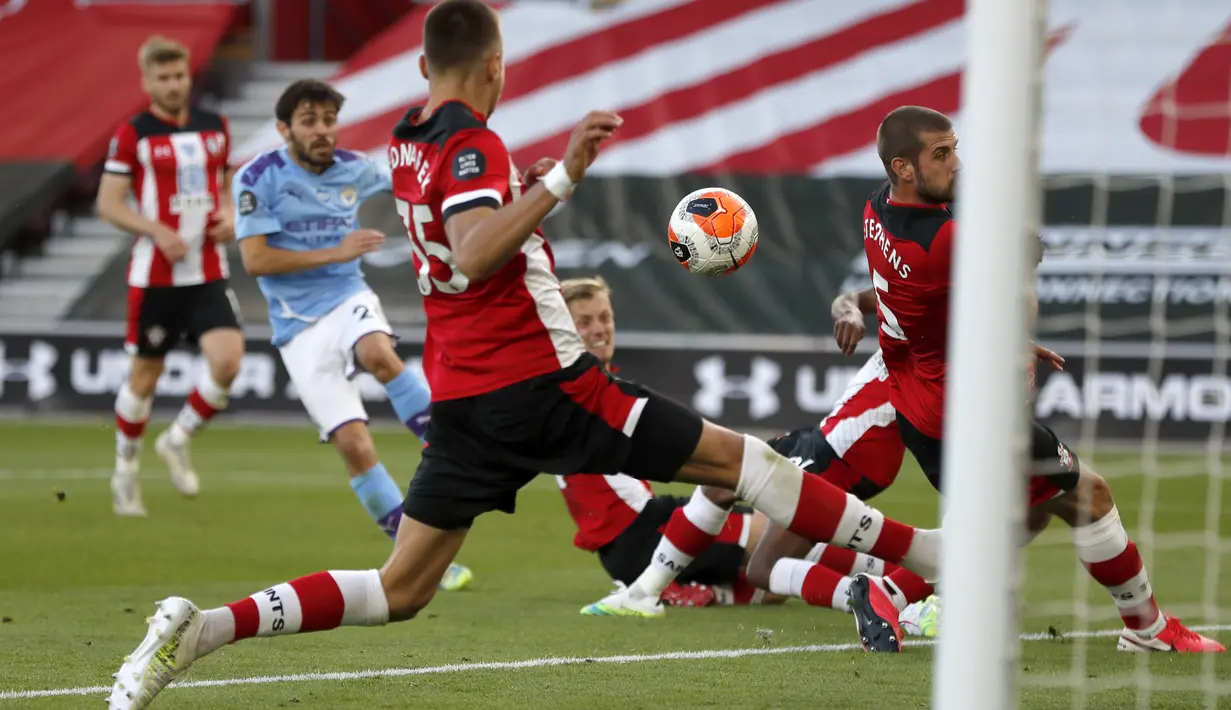 Para pemain Southampton berusaha menghalau tendangan pemain Manchester City,Bernardo Silva, pada laga Premier League di Stadion St. Mary's, Minggu (5/7/2020). Manchester City takluk 0-1 dari Southampton. (AP Photo/Frank Augstein,Pool)
