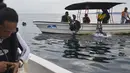 Wisatawan melompat ke air untuk menyelam scuba di lokasi penyelaman di Iboih, taman pantai dan pariwisata yang populer di seberang teluk dari Sabang di pulau Weh, provinsi Aceh (6/10/2019). (AFP Photo/Chaideer Mahyuddin)