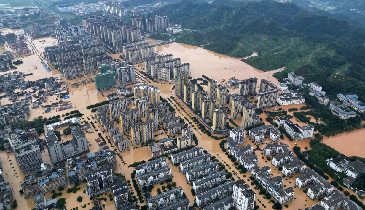 Sebelumnya dilaporkan 80.900 orang mengungsi akibat banjir yang melanda daerah Rongjiang, Guizhou, barat daya China sejak Selasa 24 Juni 2025. Tampak dalam foto udara yang menunjukkan bangunan-bangunan yang terendam banjir di Rongjiang, provinsi Guizhou barat daya China pada 24 Juni 2025. (AFP/China OUT)