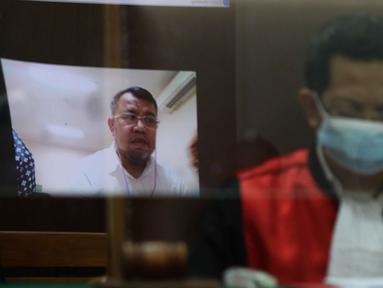 Ketua Majelis Hakim Hariyadi dan terdakwa mantan Presiden ACT Ahyudin (dalam pantulan layar) saat menjalani sidang perdana secara virtual di Pengadilan Negeri Jakarta Selatan, Jakarta, Selasa (15/11/2022). Sidang tersebut beragendakan pembacaan dakwaan terkait perkara dugaan penggelapan dana bantuan Boeing oleh Aksi Cepat Tanggap (ACT) dengan terdakwa mantan Presiden ACT Ahyudin. (Liputan6.com/Herman Zakharia)