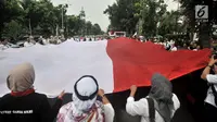 Massa GJI membentangkan bendera Merah Putih raksasa saat menggelar aksi menuntut Gubernur DKI Jakarta Anies Baswedan untuk mencabut izin penyelanggaraan Reuni 212 di depan Balai Kota, Jakarta, Kamis (29/11). (Merdeka.com/Iqbal S. Nugroho)